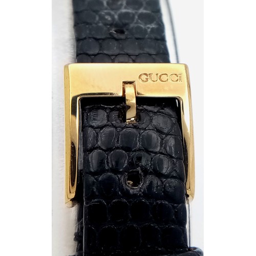 564 - A Gucci gold plated ladies quartz wristwatch with black leather strap, 14mm case diameter, in good w... 