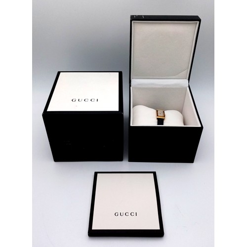 564 - A Gucci gold plated ladies quartz wristwatch with black leather strap, 14mm case diameter, in good w... 