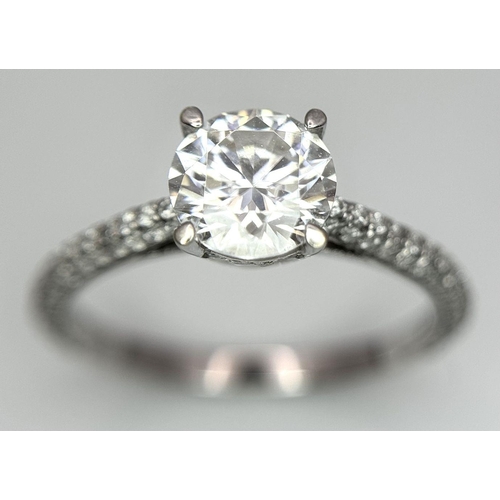 43 - An 18K White Gold Diamond Ring. Brilliant round cut 1ct diamond with a further 0.5ctw of diamonds on... 