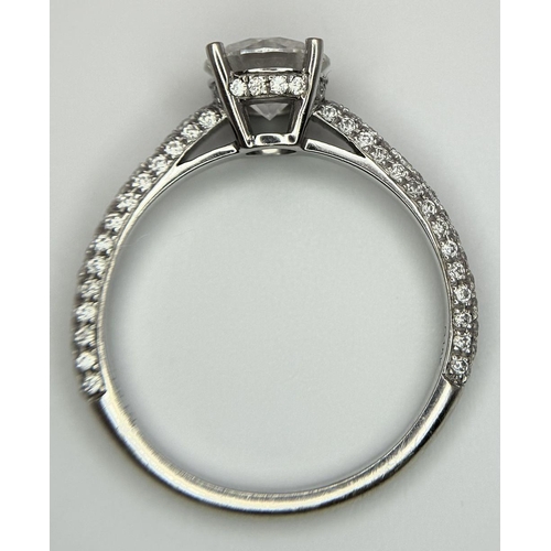 43 - An 18K White Gold Diamond Ring. Brilliant round cut 1ct diamond with a further 0.5ctw of diamonds on... 