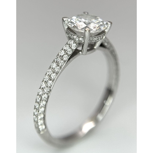 43 - An 18K White Gold Diamond Ring. Brilliant round cut 1ct diamond with a further 0.5ctw of diamonds on... 