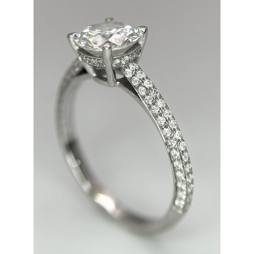 43 - An 18K White Gold Diamond Ring. Brilliant round cut 1ct diamond with a further 0.5ctw of diamonds on... 