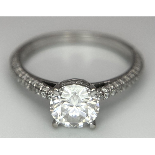 43 - An 18K White Gold Diamond Ring. Brilliant round cut 1ct diamond with a further 0.5ctw of diamonds on... 