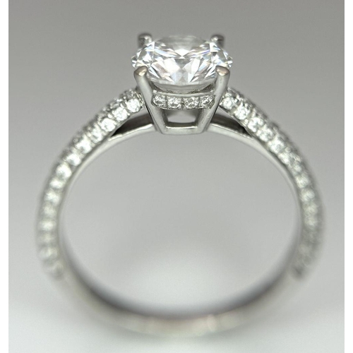 43 - An 18K White Gold Diamond Ring. Brilliant round cut 1ct diamond with a further 0.5ctw of diamonds on... 