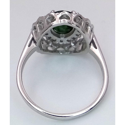 61 - A Green Peridot and Diamond Ring. Set in 925 Silver. Central oval peridot with two halos of diamonds... 