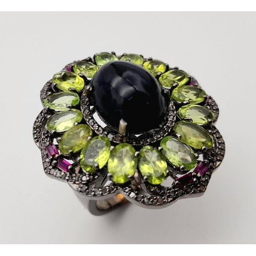 917 - A Peridot, Opal, Ruby and Diamond Ring. Set in 925 silver. Central black opal cabochon with peridot ... 
