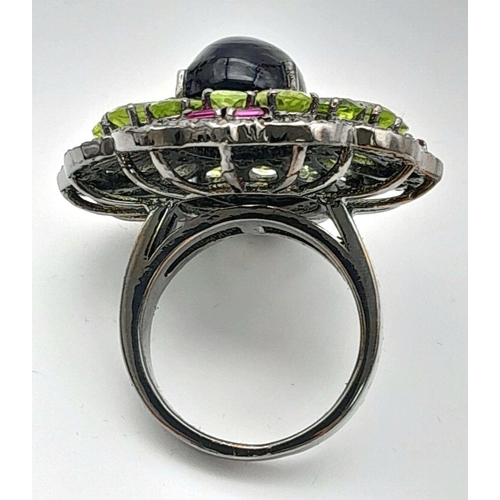 917 - A Peridot, Opal, Ruby and Diamond Ring. Set in 925 silver. Central black opal cabochon with peridot ... 