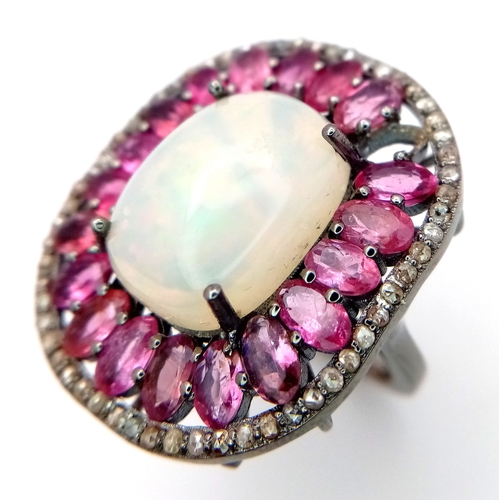 848 - A 925 sterling silver ring featuring a central opal stone surrounded by pink tourmaline stones. Ring... 
