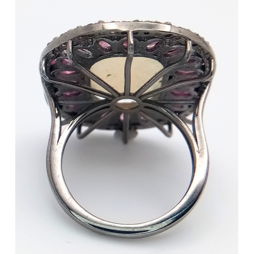 848 - A 925 sterling silver ring featuring a central opal stone surrounded by pink tourmaline stones. Ring... 