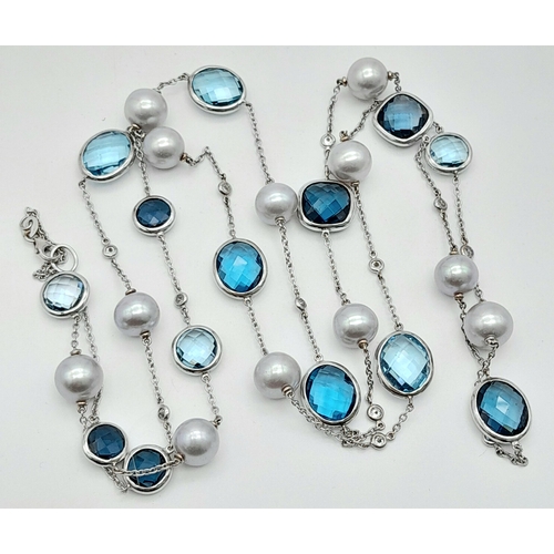 545 - An 18K White Gold, Pearl, Diamond and Topaz Matinee Length Necklace. 82cm.33.5g total weight.