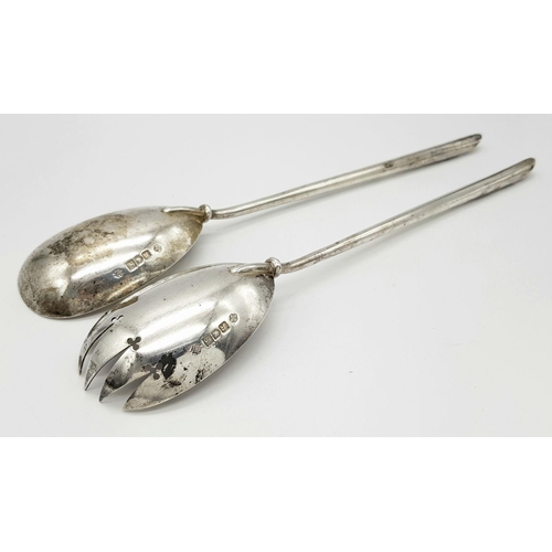 148 - A pair of antique London hallmarked 1902 silver salad servers featuring a sleek, timeless design. Ap... 