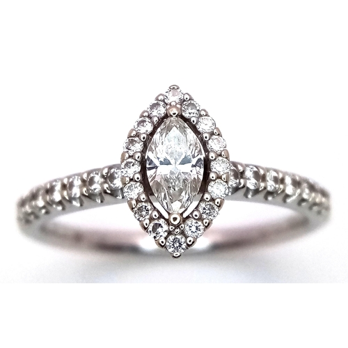 115 - An 18K White Gold Diamond Ring. Marquise cut central diamond with with round cut diamond surround an... 