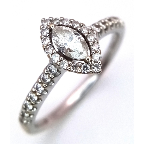 115 - An 18K White Gold Diamond Ring. Marquise cut central diamond with with round cut diamond surround an... 