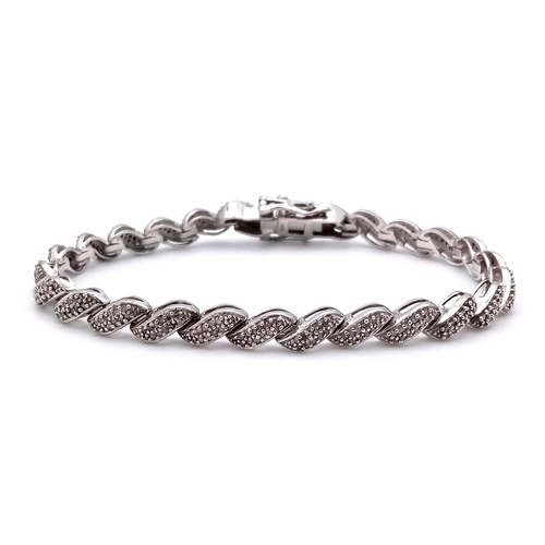 14 - A Hallmarked Sterling Silver Diamond Set Tennis Bracelet 19.5cm Length. Set with a profusion of roun... 