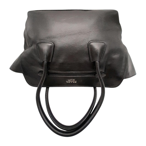 80 - A Prada City Calf Nero Handbag. Black city calf leather exterior with silver-toned hardware, dual le... 