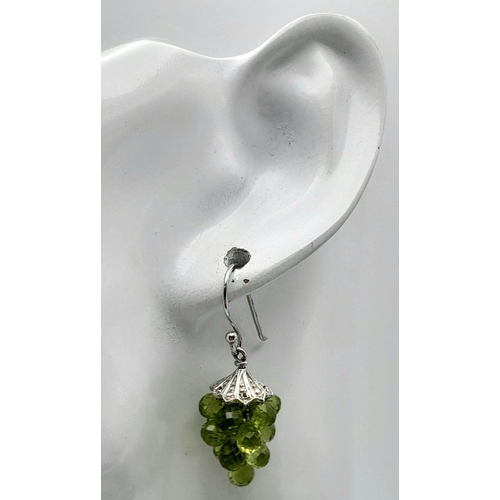 908 - A Unique Pair of Sterling Silver Peridot Set ‘Bacchus’ Design Earrings. 3.5cm Drop. 1.5cm Width.