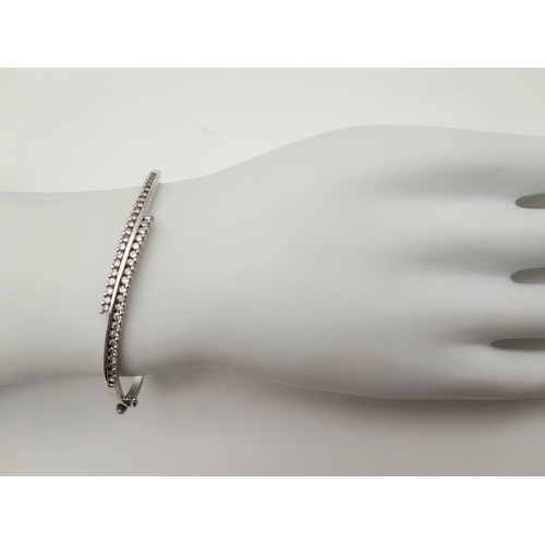 12 - A 9K White Gold and Diamond Crossover Bracelet. Two waves of diamonds create a stunning piece. Clip ... 