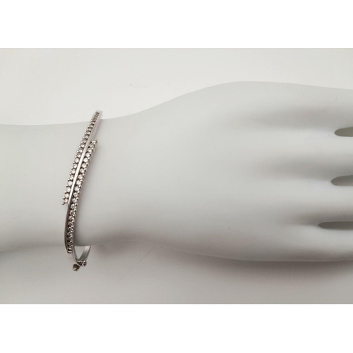 12 - A 9K White Gold and Diamond Crossover Bracelet. Two waves of diamonds create a stunning piece. Clip ... 