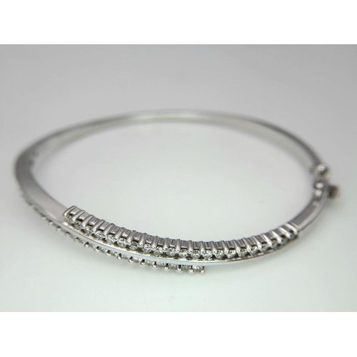 12 - A 9K White Gold and Diamond Crossover Bracelet. Two waves of diamonds create a stunning piece. Clip ... 