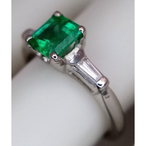 64 - A Platinum Emerald Ring. A 0.75ct Emerald Cut centre stone with tapered baguette diamond shoulders. ... 