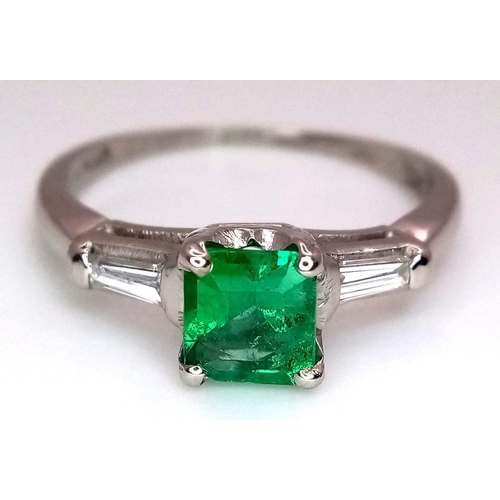 64 - A Platinum Emerald Ring. A 0.75ct Emerald Cut centre stone with tapered baguette diamond shoulders. ... 