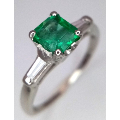 64 - A Platinum Emerald Ring. A 0.75ct Emerald Cut centre stone with tapered baguette diamond shoulders. ... 