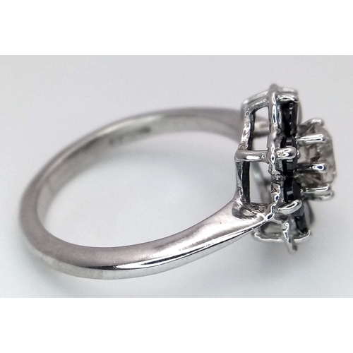 687 - A Vintage 9K White Gold, Diamond and Sapphire Ring. Central 0.75ct brilliant round cut diamond with ... 