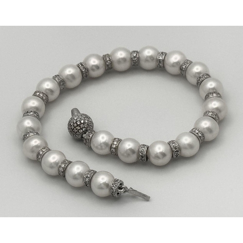 715 - An 18K White Gold, South Sea Pearl Bracelet with Diamond Cluster Spacers. 19.5g total weight.