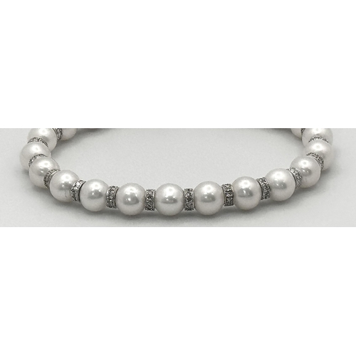 715 - An 18K White Gold, South Sea Pearl Bracelet with Diamond Cluster Spacers. 19.5g total weight.