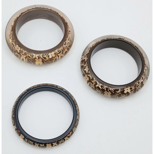 949 - Three Decorative Louis Vuitton Dress Bangles. 10mm and 2 x 22mm widths. 64mm inner diameters. Monogr... 