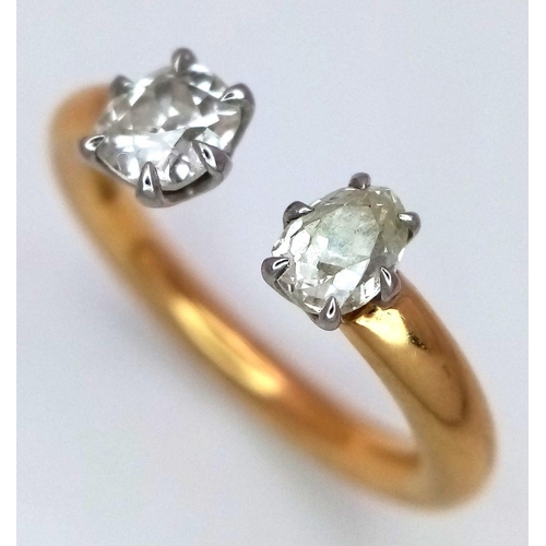 563 - An 18K Gold and Diamond Open Ring. Platinum setting. Oval and brilliant round cut diamond - 0.80ctw.... 