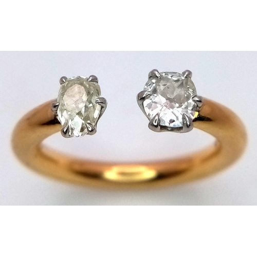 563 - An 18K Gold and Diamond Open Ring. Platinum setting. Oval and brilliant round cut diamond - 0.80ctw.... 