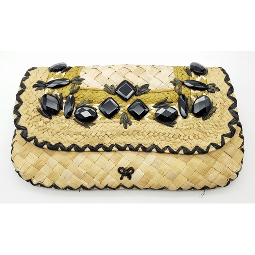 668 - An Anya Hindmarch Handwoven Straw Clutch with Black Bead Embellishments. Natural straw exterior feat... 