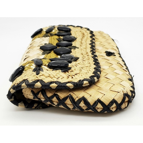 668 - An Anya Hindmarch Handwoven Straw Clutch with Black Bead Embellishments. Natural straw exterior feat... 