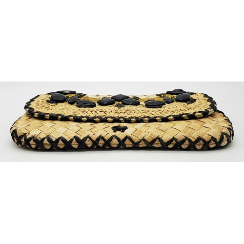 668 - An Anya Hindmarch Handwoven Straw Clutch with Black Bead Embellishments. Natural straw exterior feat... 