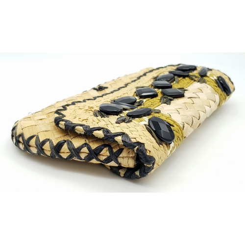 668 - An Anya Hindmarch Handwoven Straw Clutch with Black Bead Embellishments. Natural straw exterior feat... 