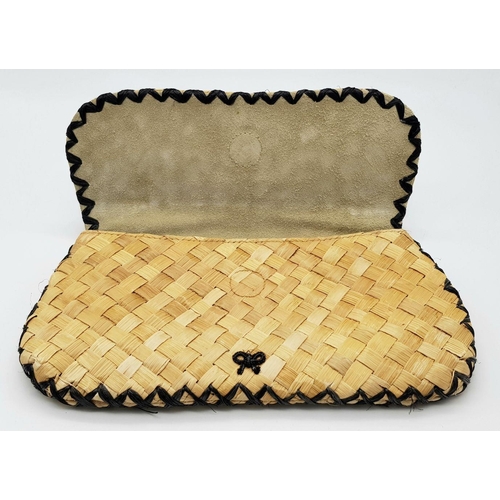 668 - An Anya Hindmarch Handwoven Straw Clutch with Black Bead Embellishments. Natural straw exterior feat... 