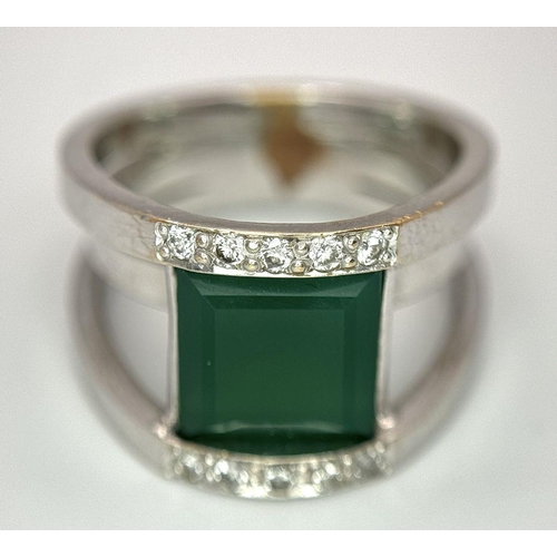 367 - A 21k White Gold, Emerald and Diamond Orbital Ring. A large 3ct square cut central emerald with diam... 