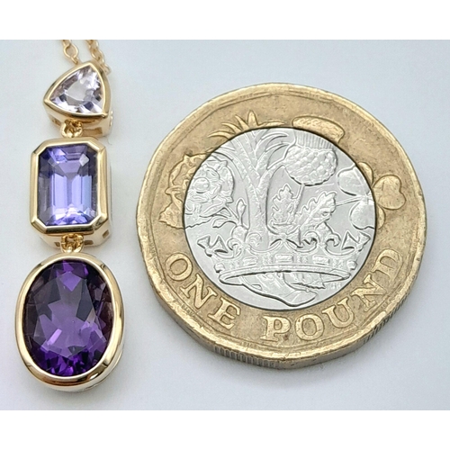 100 - AN 18K YELLOW GOLD TANZANITE & AMETHYST DROP PENDANT. 4.8G IN WEIGHT. APPROX. 45CM IN LENGTH. Ref: A... 