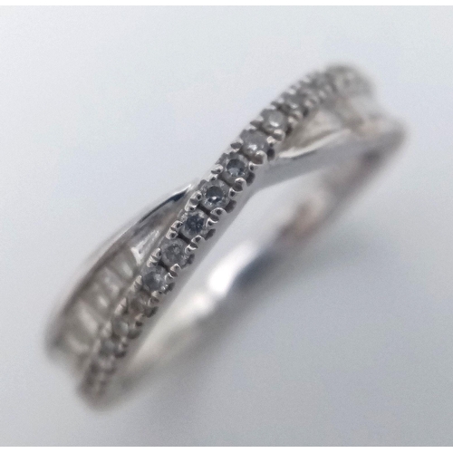 135 - AN 18K WHITE GOLD CROSSOVER MIXED CUT DIAMOND RING. 0.25CT. 3.35G IN WEIGHT. SIZE J. Ref: SC 1046