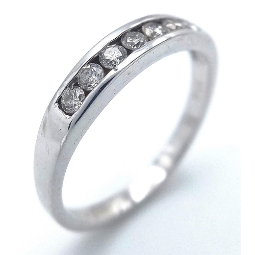 254 - AN 18K WHITE GOLD DIAMOND HALF ETERNITY RING CHANNEL SET. 0.28CT DIAMONDS, 2.56G TOTAL WEIGHT. SIZE ... 