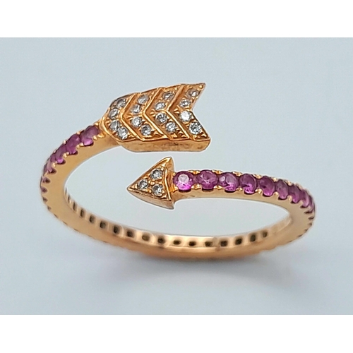 296 - AN 18K ROSE GOLD DIAMOND & RUBY ARROW DESIGN RING. 2.2G IN WEIGHT. SIZE L. Ref: SC 1069