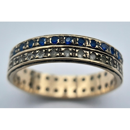 462 - Extremely pretty 9 CARAT GOLD BAND RING. Set with Blue and Clear gemstones in tramline style. 2.5 gr... 