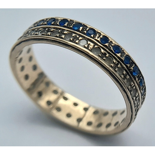 462 - Extremely pretty 9 CARAT GOLD BAND RING. Set with Blue and Clear gemstones in tramline style. 2.5 gr... 