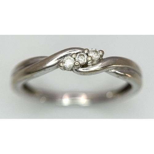 612 - A 9K White Gold Diamond Trilogy Crossover Ring. Size L 1/2. 
1.7g total weight.