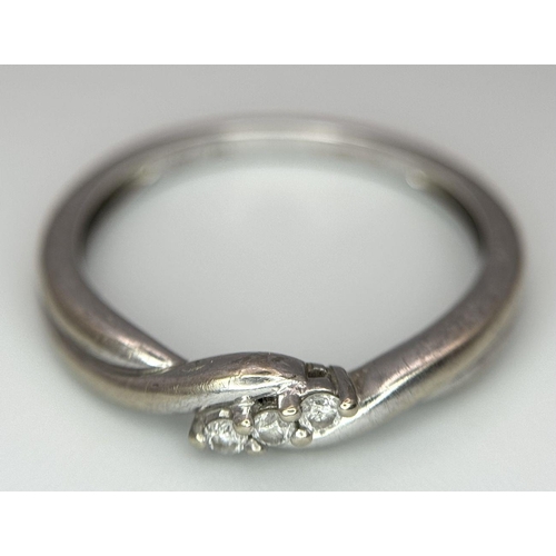 612 - A 9K White Gold Diamond Trilogy Crossover Ring. Size L 1/2. 
1.7g total weight.