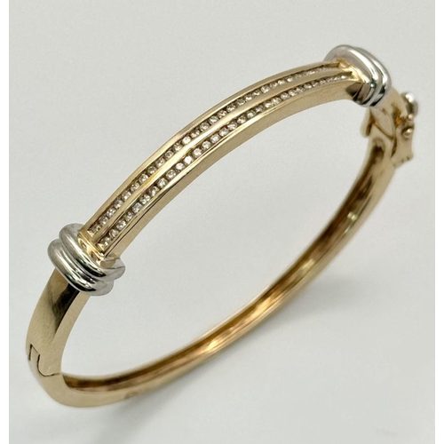 124 - A Stylish 9K Yellow and White Gold, Diamond Bangle. 62 small round cut diamonds over two levels. Cli... 