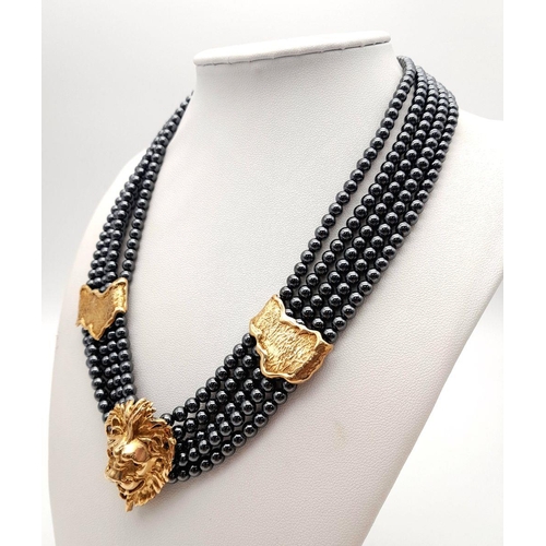 376 - A 9K Gold Clasped Lion's Head Five Row Haematite Necklace. 
44cm.