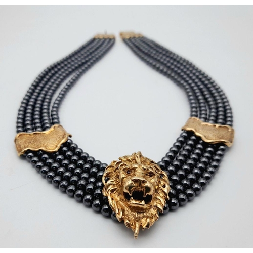 376 - A 9K Gold Clasped Lion's Head Five Row Haematite Necklace. 
44cm.