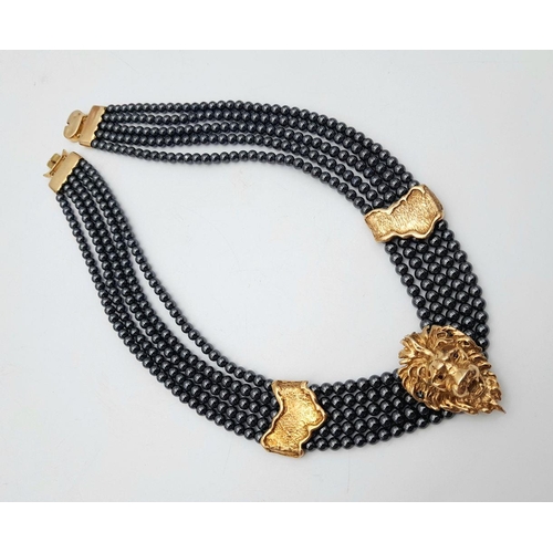 376 - A 9K Gold Clasped Lion's Head Five Row Haematite Necklace. 
44cm.